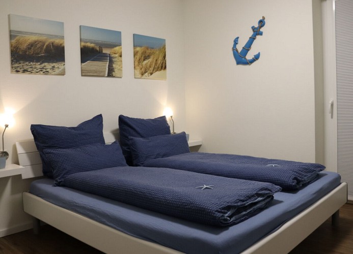 Ankerplatz Sielhuus - Deine Ferien - Schlafzimmer 1 mit großem Fernseher und Doppelbett